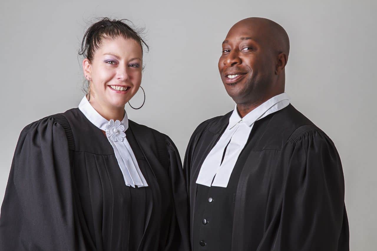 Deux avocats en robe de juge, symbolisant la justice et le service juridique à Performance Juridique.