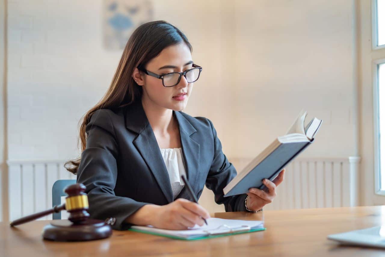 Lawyer woman reviewing legal book in office, justice and legal advice, female lawyer working, professional legal consultation.