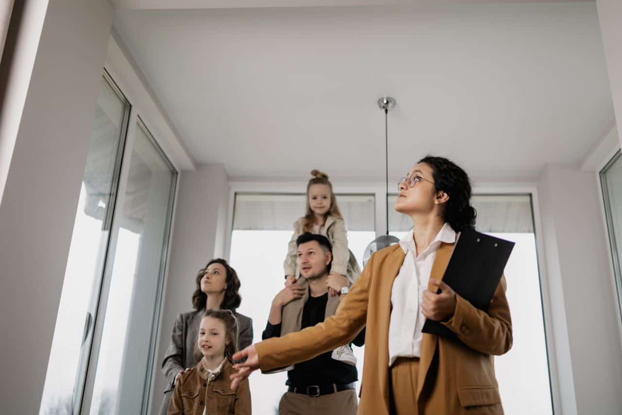 Foto d'une femme conseillant une famille devant un appartement. Expertise juridique familiale, droit de la famille, assistance juridique confiance.